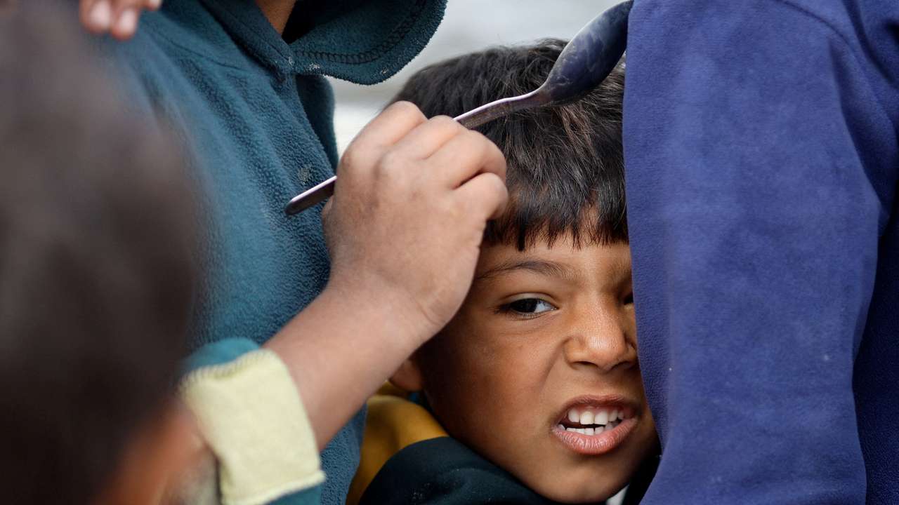 Palestinians wait to receive food amid shortages of food supplies, in Rafah