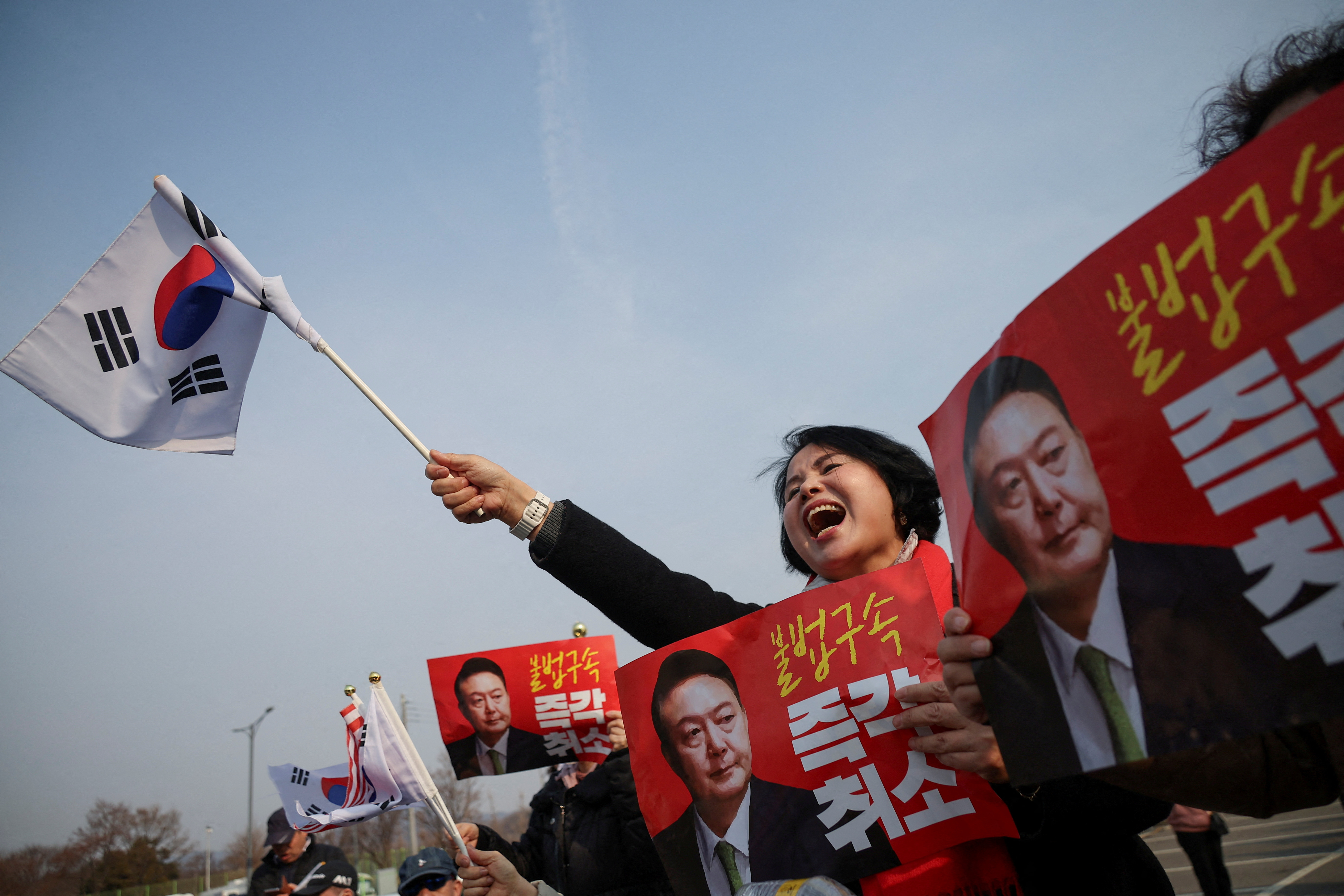 Supporters of South Korean impeached President Yoon Suk Yeol cheer after the court decided to release him, in front of the Seoul detention center in Uiwang