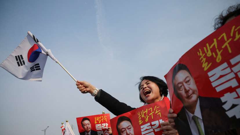 Supporters of South Korean impeached President Yoon Suk Yeol cheer after the court decided to release him, in front of the Seoul detention center in Uiwang