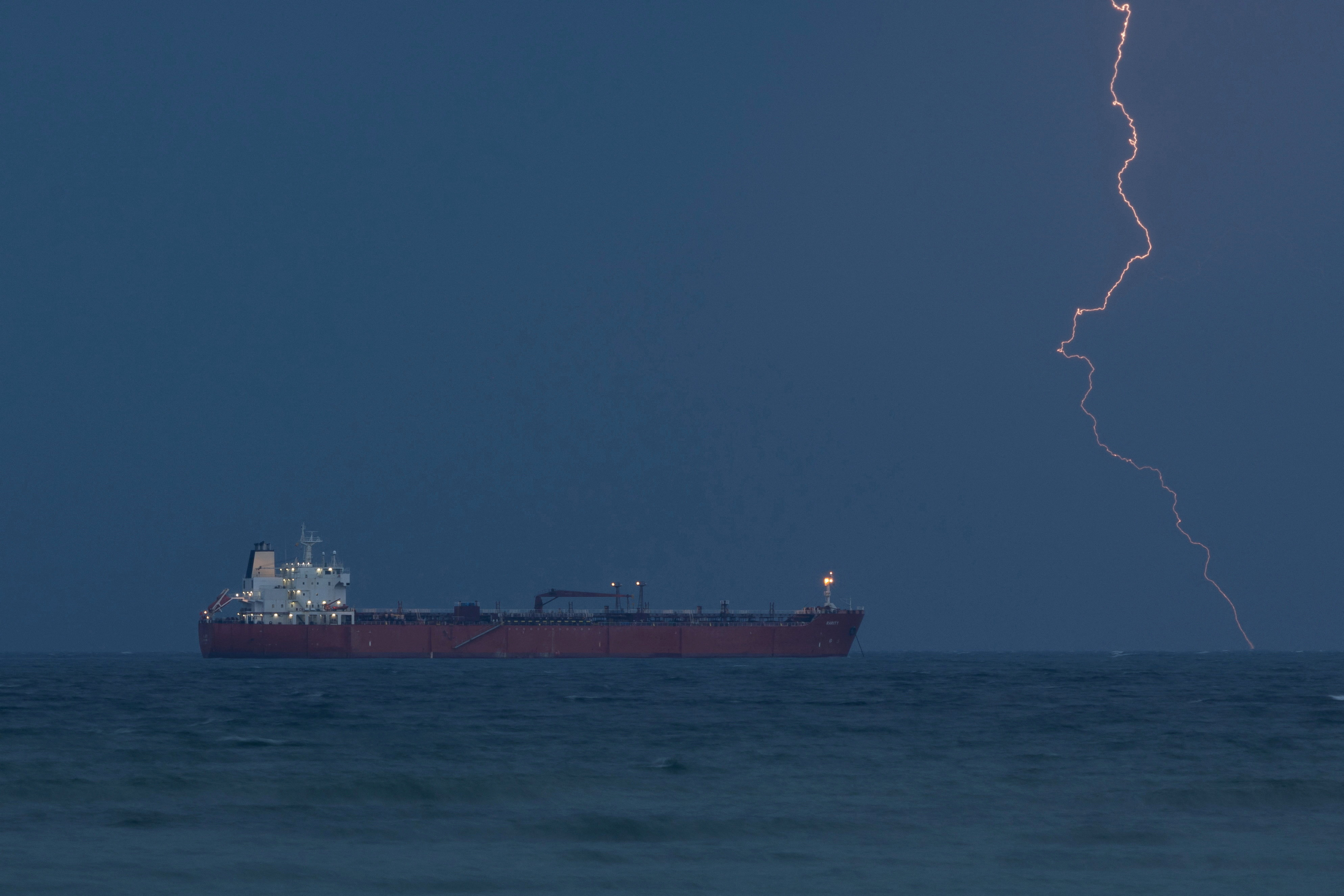 Tanker RARITY sits at anchor off Muscat coast as lightning flashes