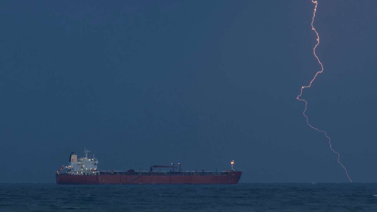 Tanker RARITY sits at anchor off Muscat coast as lightning flashes