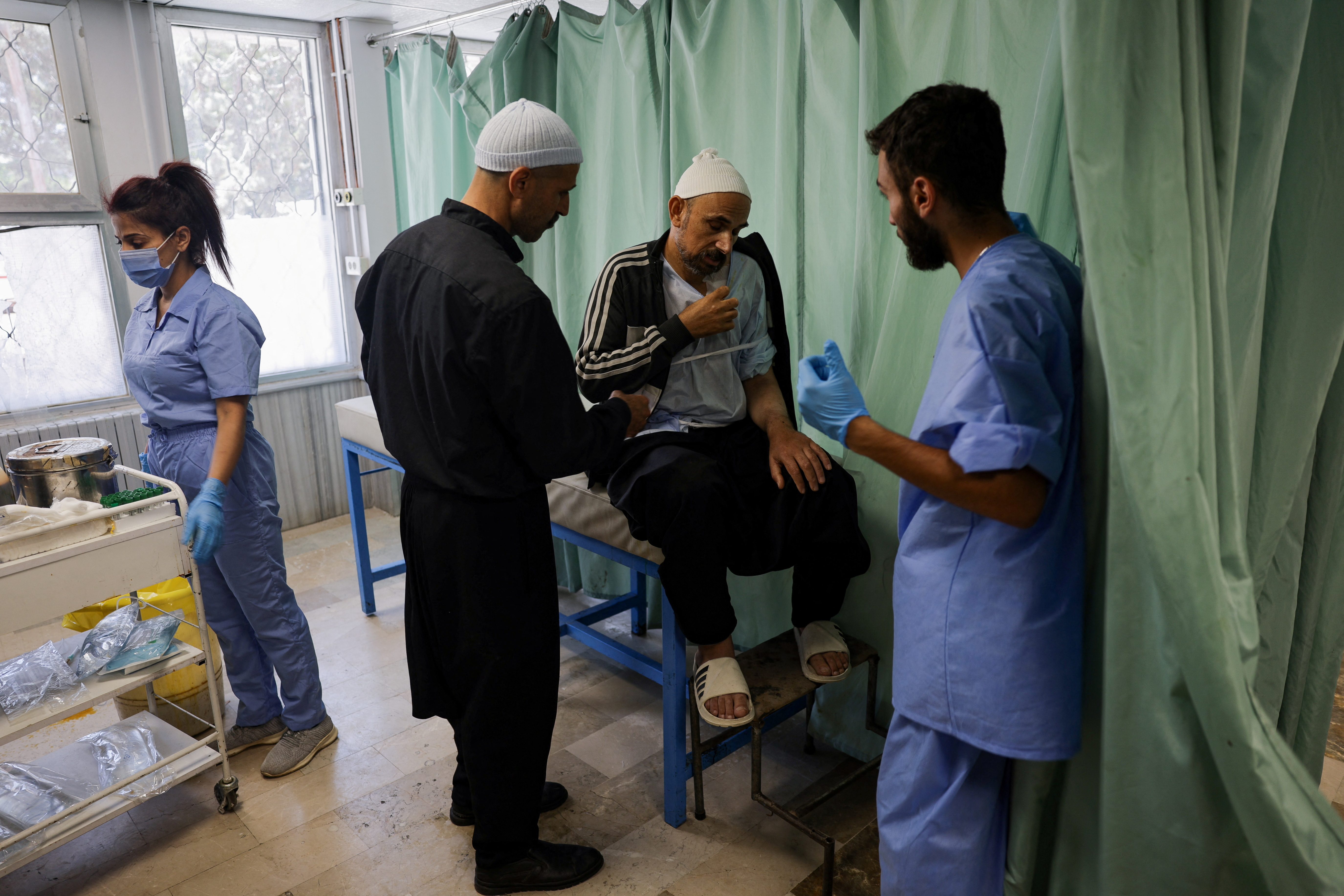 Health workers assist people at a hospital, in Sweida