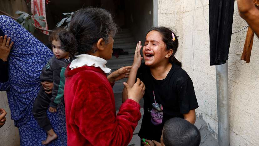 Palestinian children react after an Israeli strike on a house, amid the ongoing conflict between Israel and Palestinian Islamist group Hamas, in Khan Younis