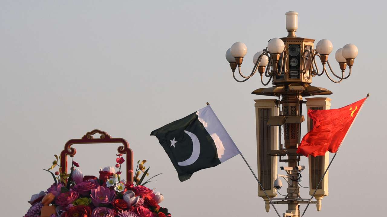 Pakistani and Chinese national flags flutter next to an installation featuring a giant flower basket at the Tiananmen Square in Beijing