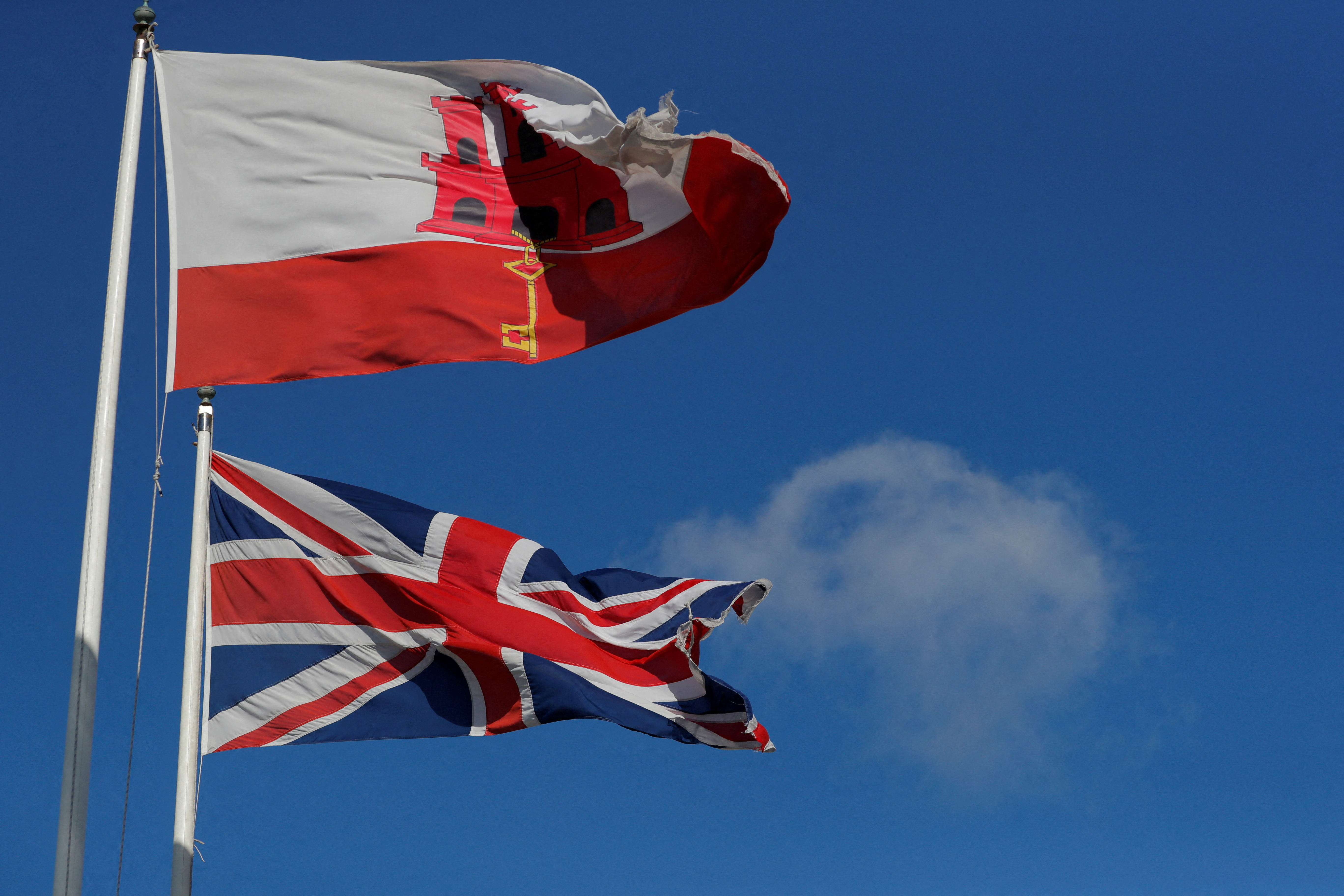 FILE PHOTO: The Gibraltarian and Britain's Union Jack flags fly at the border between Spain and Gibraltar