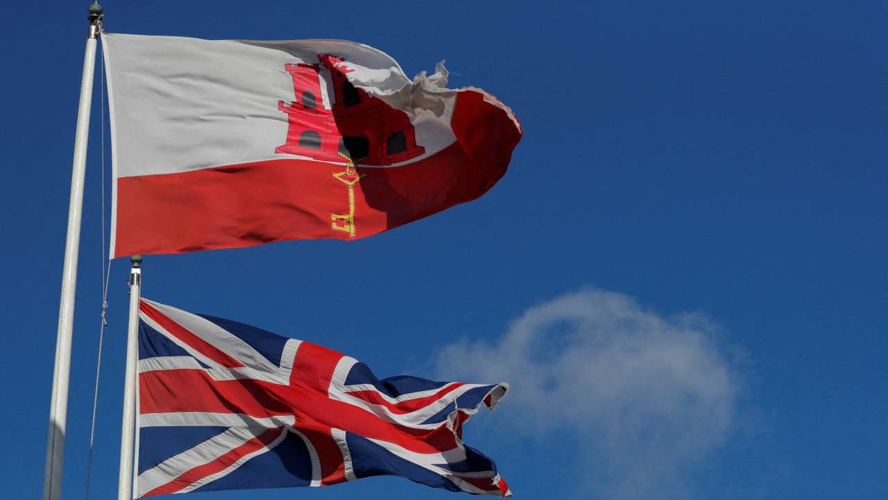 FILE PHOTO: The Gibraltarian and Britain's Union Jack flags fly at the border between Spain and Gibraltar