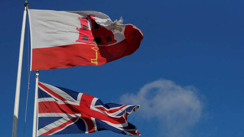 FILE PHOTO: The Gibraltarian and Britain's Union Jack flags fly at the border between Spain and Gibraltar