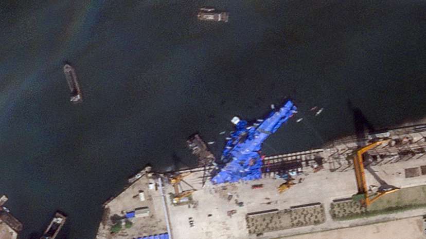 A satellite image shows a North Korean warship covered with a blue tarp after an accident that occurred during its launch at the shipyard in Chongjin