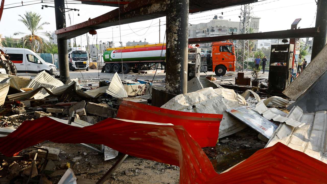 Palestinians inspect a petrol station that was hit in an Israeli strike in Khan Younis