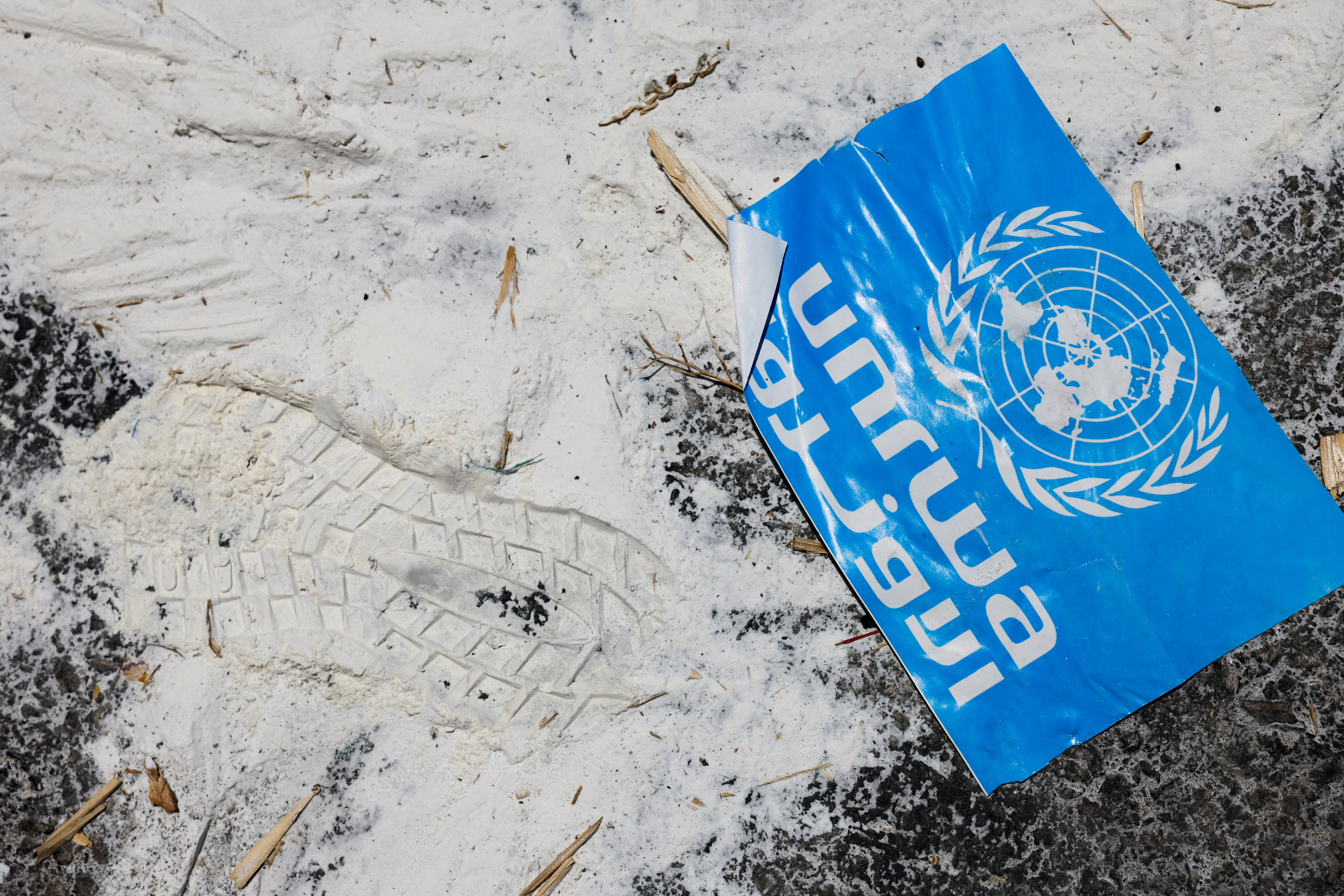 FILE PHOTO: A United Nations Relief and Works Agency (UNRWA) sign lies on the ground, amid the ongoing conflict in Gaza between Israel and the Palestinian Islamist group Hamas,  at the Kerem Shalom crossing in southern Israel