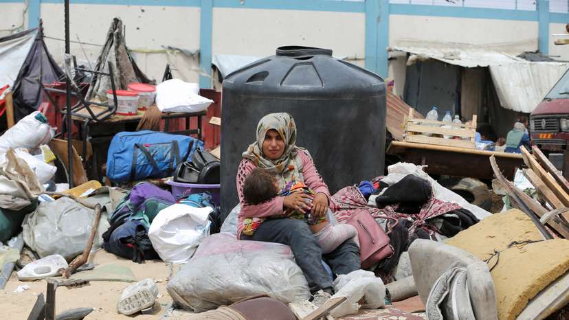 Palestinians travel on foot along with their belongings as they flee Rafah due to an Israeli military operation