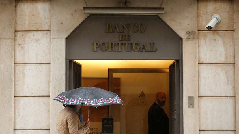 FILE PHOTO: A woman walks outside Bank of Portugal in downtown Lisbon