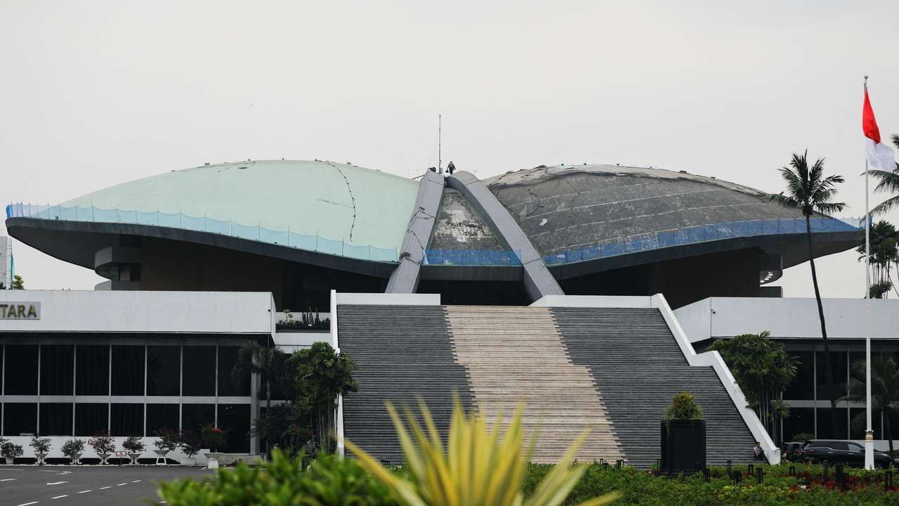 A worker walks on the roof of Indonesian Parliament Building in Jakarta