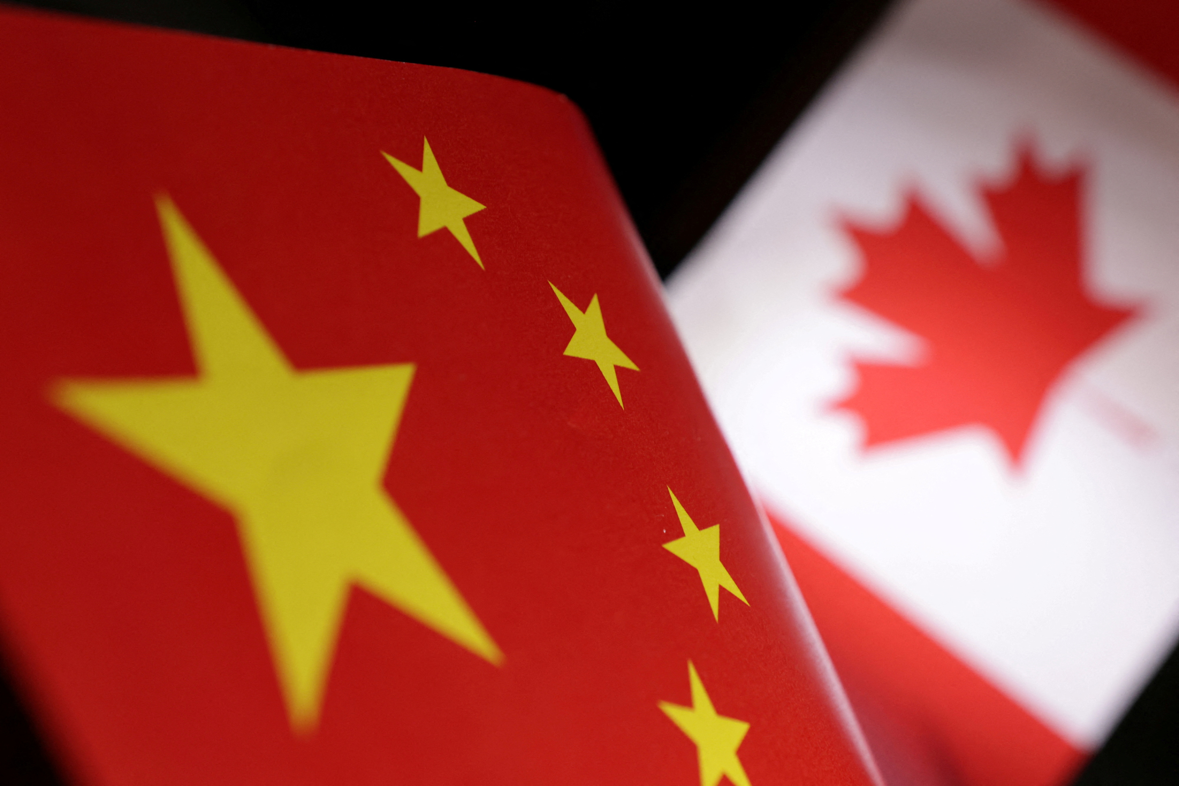 Illustration shows printed Chinese and Canada flags