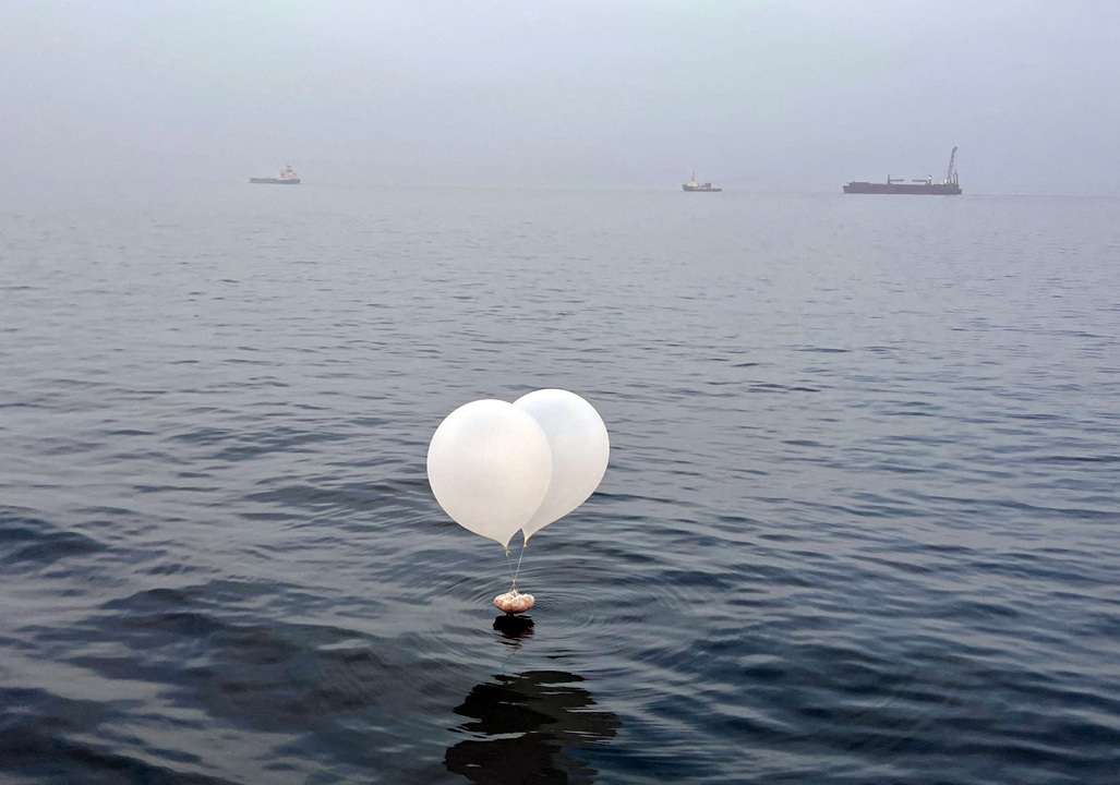 A balloon carrying various objects including what appeared to be trash, believed to have been sent by North Korea, is pictured at the sea off Incheon