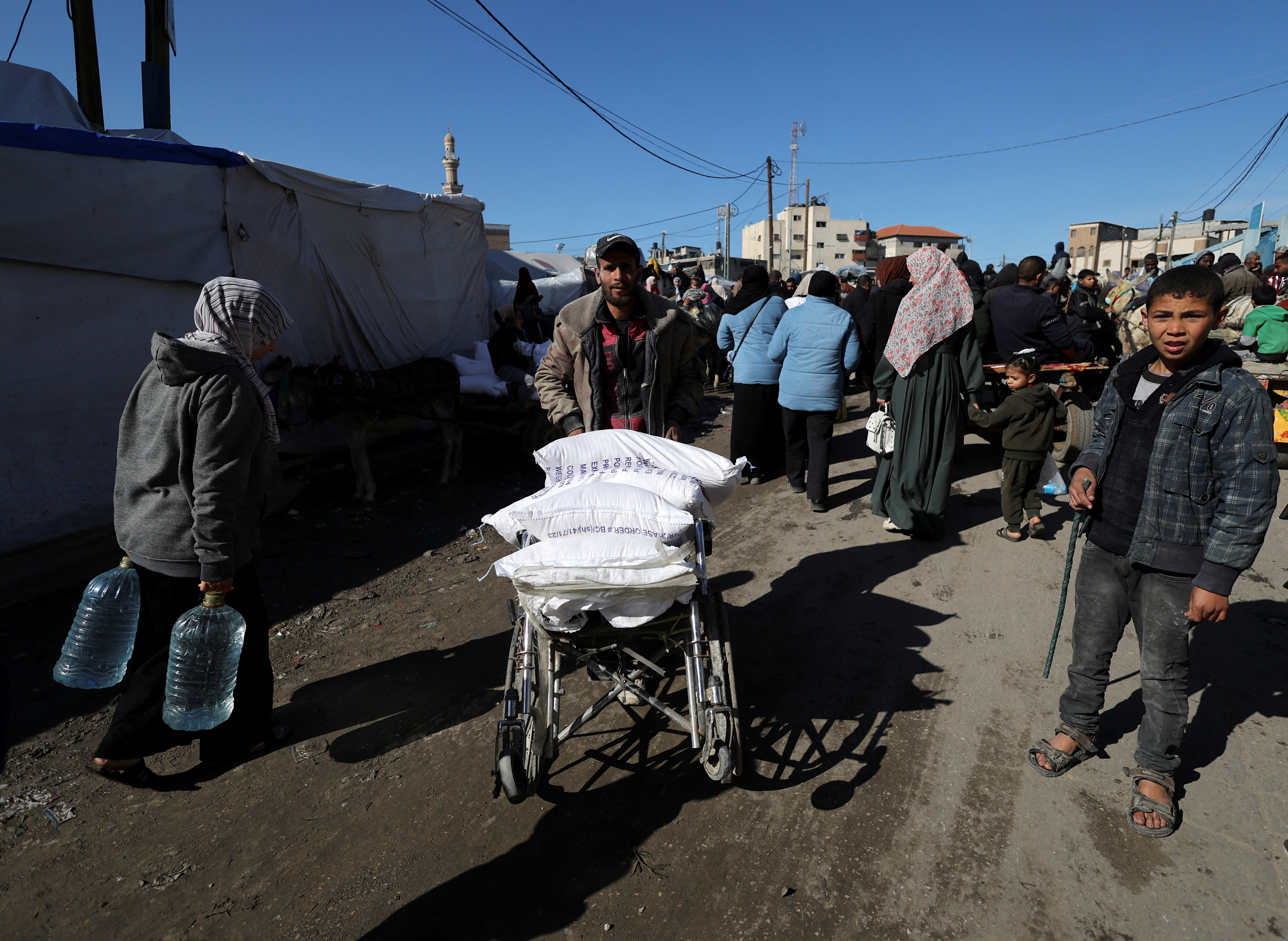 Palestinians receive bags of flour distributed by UNRWA in Rafah