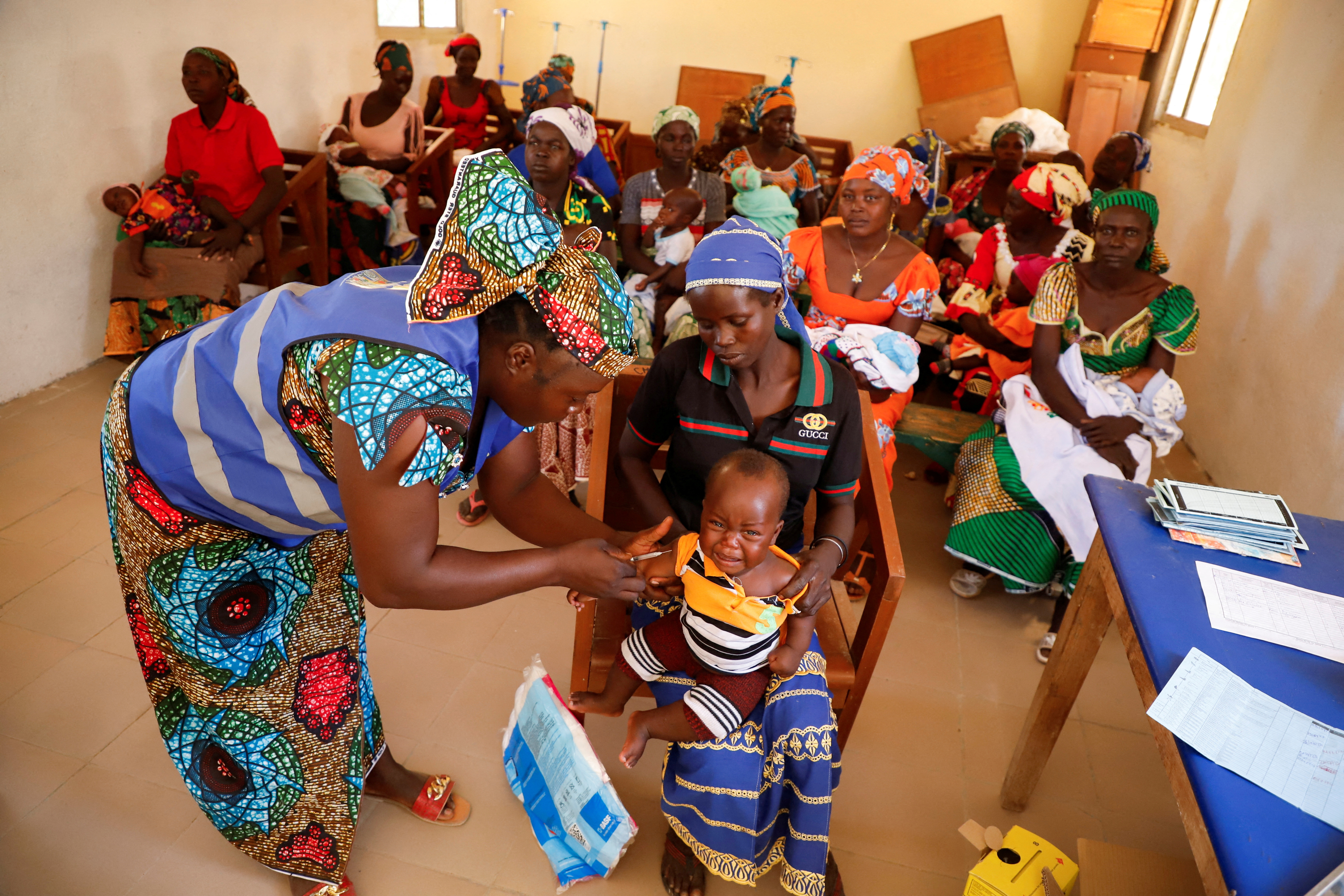 A nurse administers a malaria vaccine to an infant at the health center in Datcheka
