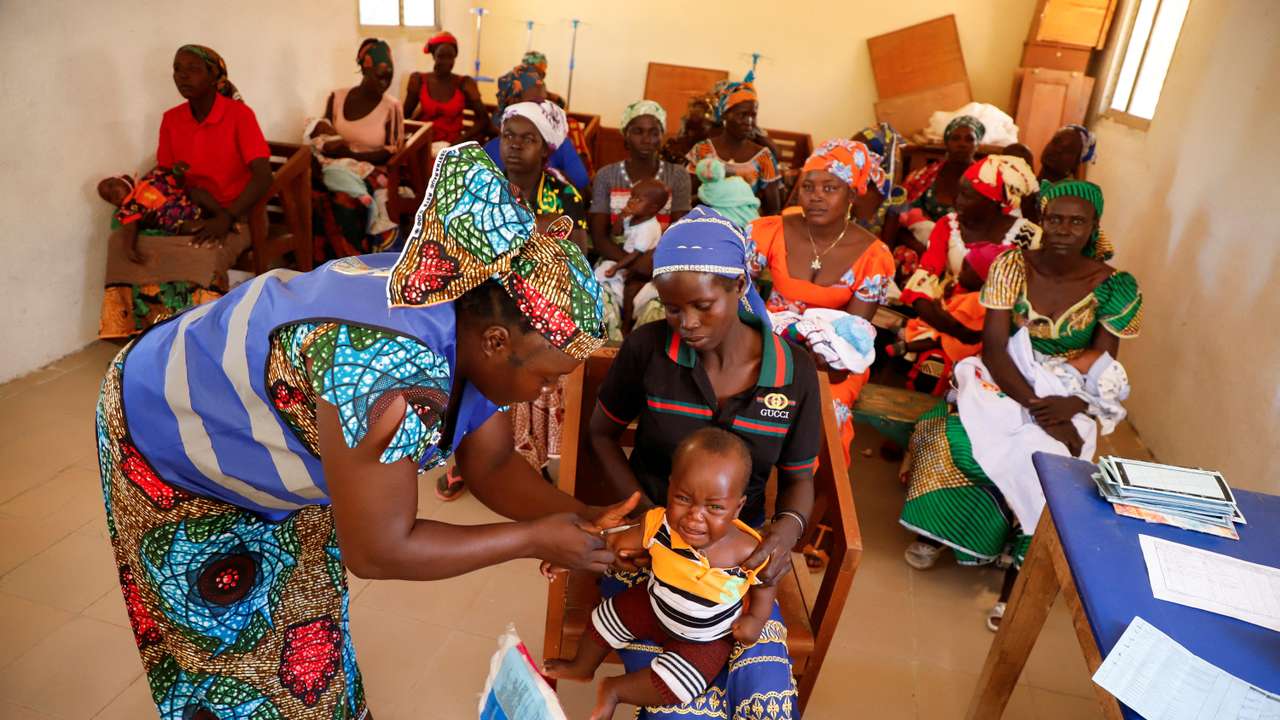 A nurse administers a malaria vaccine to an infant at the health center in Datcheka