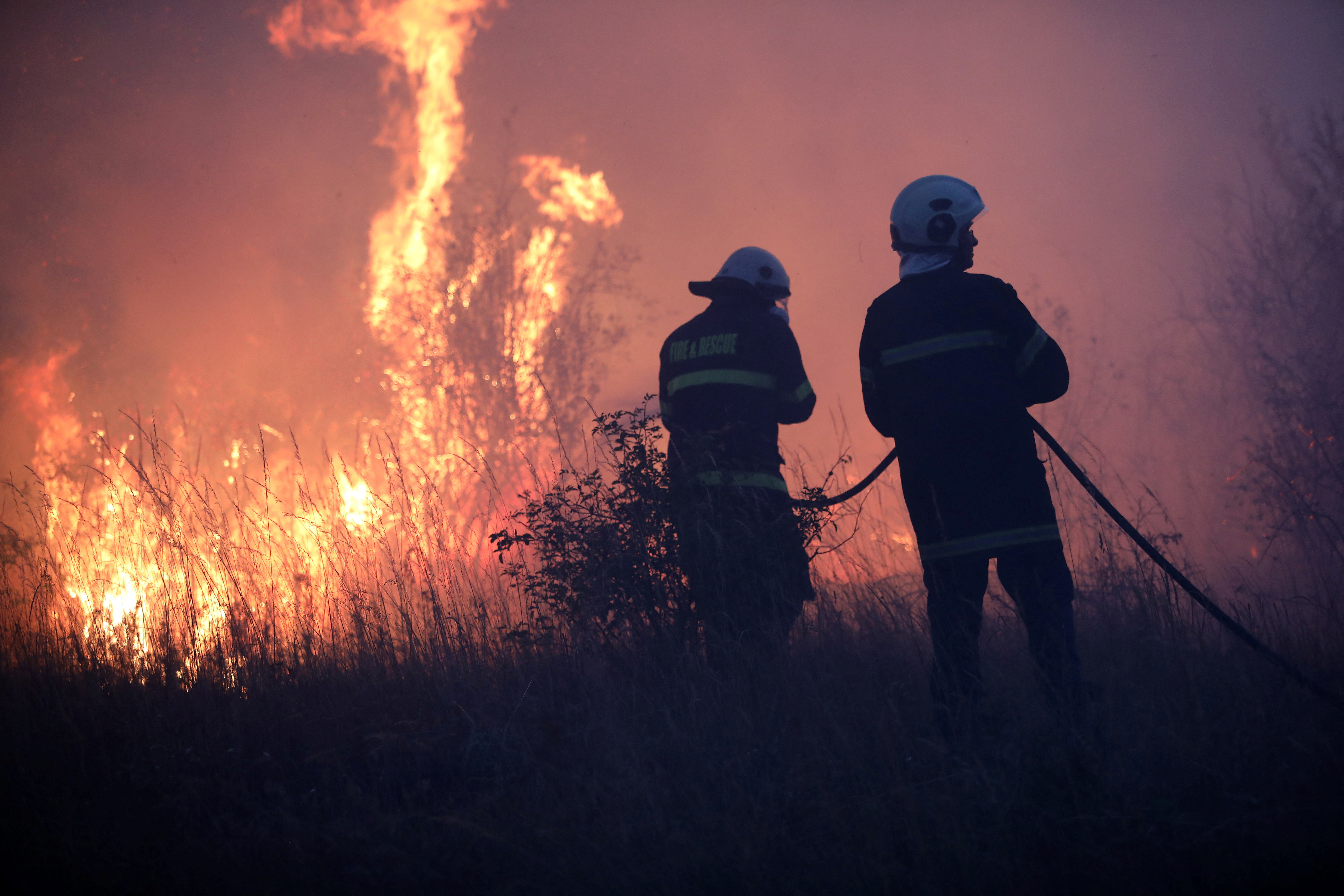Firefighters try to extinguish a wildfire near the settlement of Beledie Han
