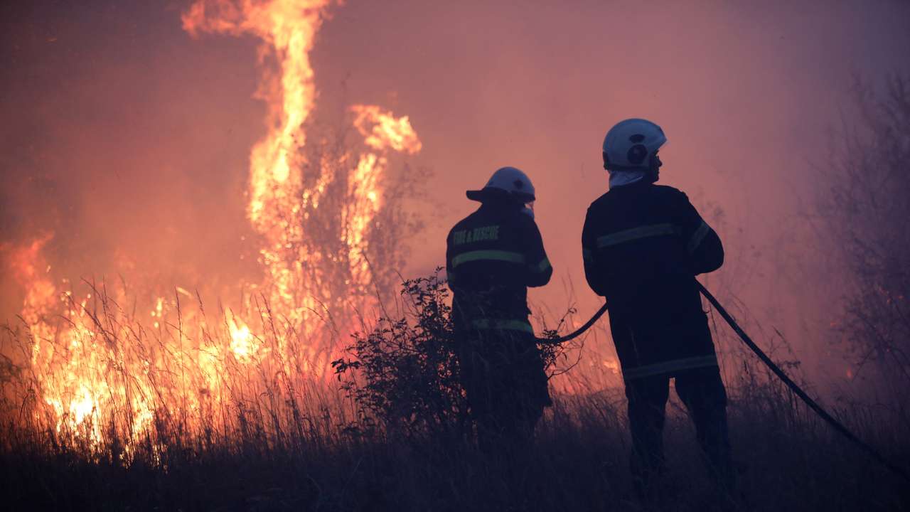 Firefighters try to extinguish a wildfire near the settlement of Beledie Han