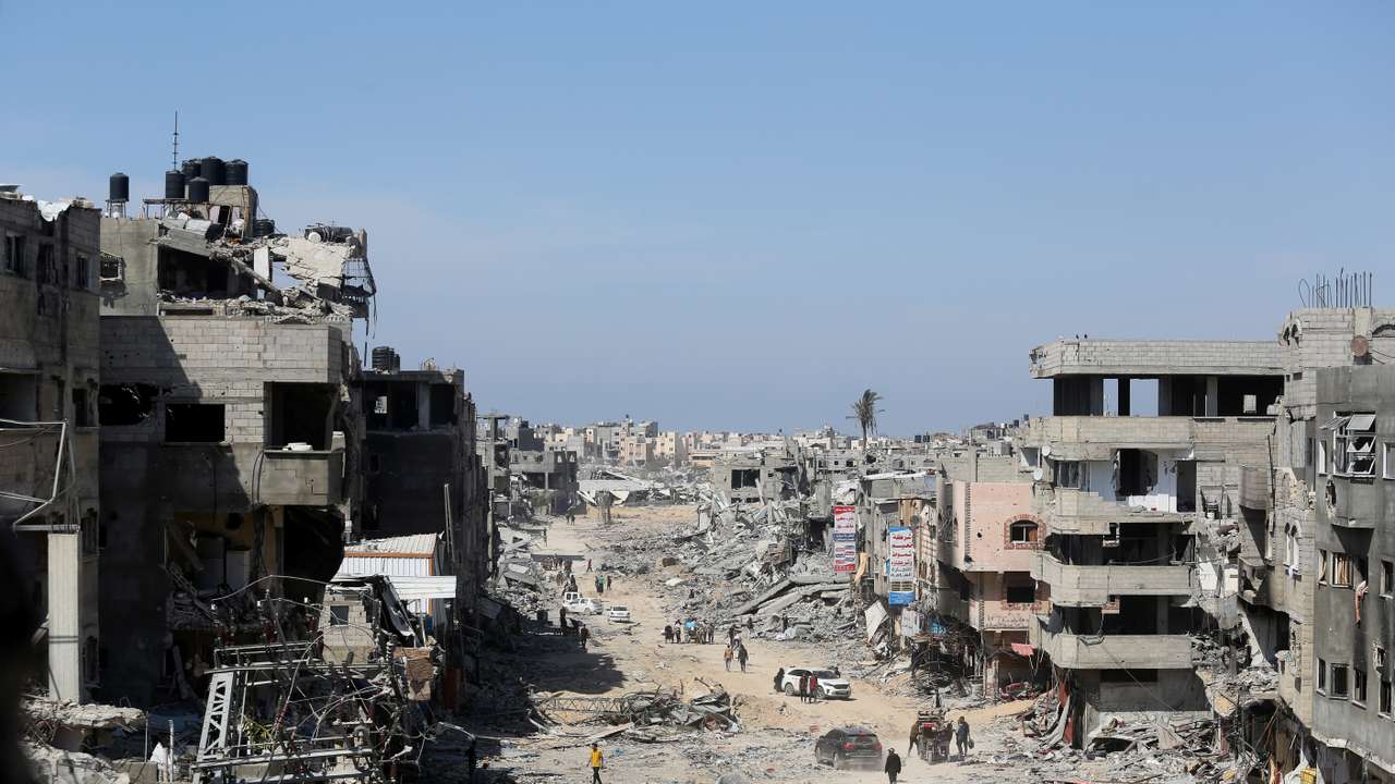 FILE PHOTO: Palestinians inspect destroyed residential buildings in Khan Younis