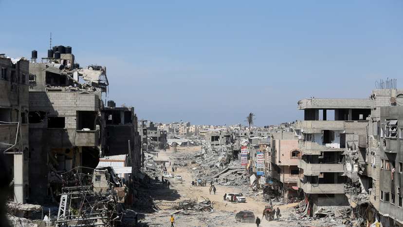 FILE PHOTO: Palestinians inspect destroyed residential buildings in Khan Younis