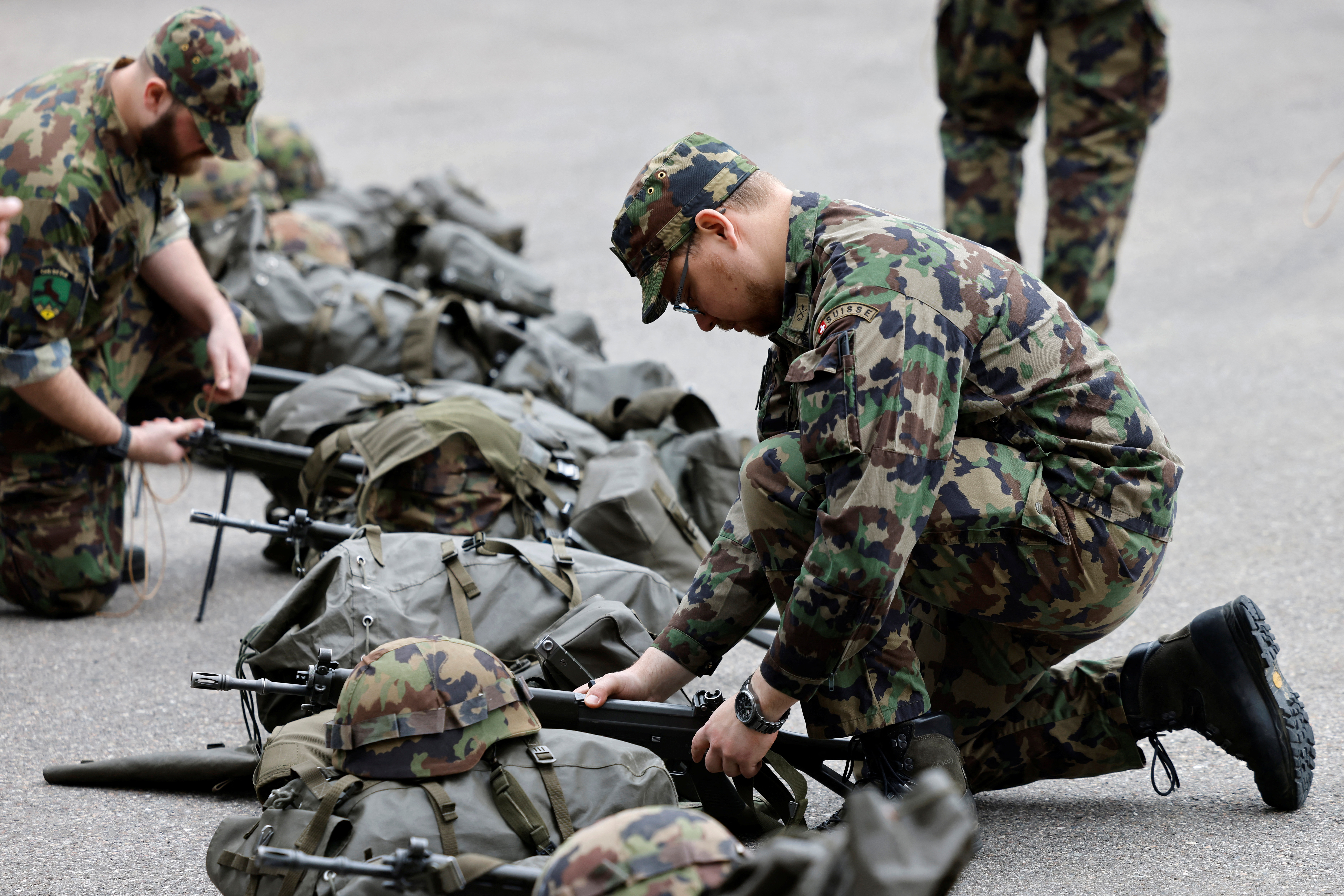 Soldiers prepare their equipment at a Swiss army base in Bure