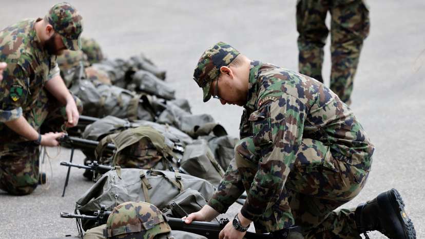 Soldiers prepare their equipment at a Swiss army base in Bure