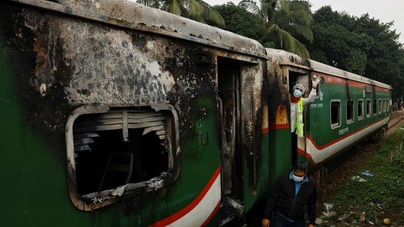 Crime Scene Unit members inspect the passenger train that was set on fire during a countrywide strike called by the Bangladesh Nationalist Party, in Dhaka