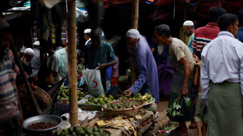 Rohingya refugees purchase vegetables from a kitchen market at a refugee camp in Cox's Bazar