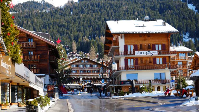 People walk next to a snow covered Verbier Swiss ski resort in Verbier