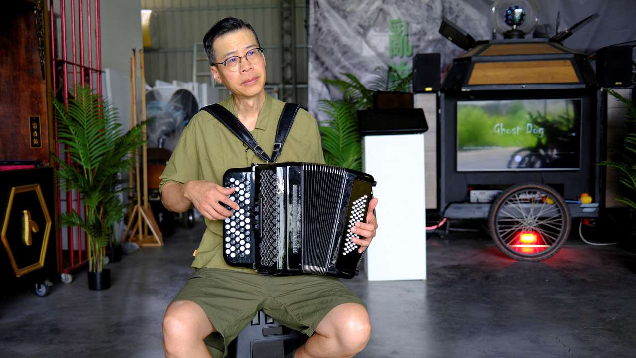 Artist Kacey Wong plays the accordion for the camera during an interview with Reuters at his studio in Taichung
