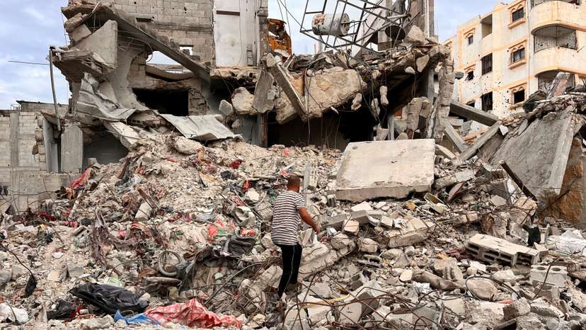 Palestinian man Moein Abu Odeh searches for clothes through the rubble of a house destroyed in the Israeli military offensive, in Khan Younis in the southern Gaza Strip