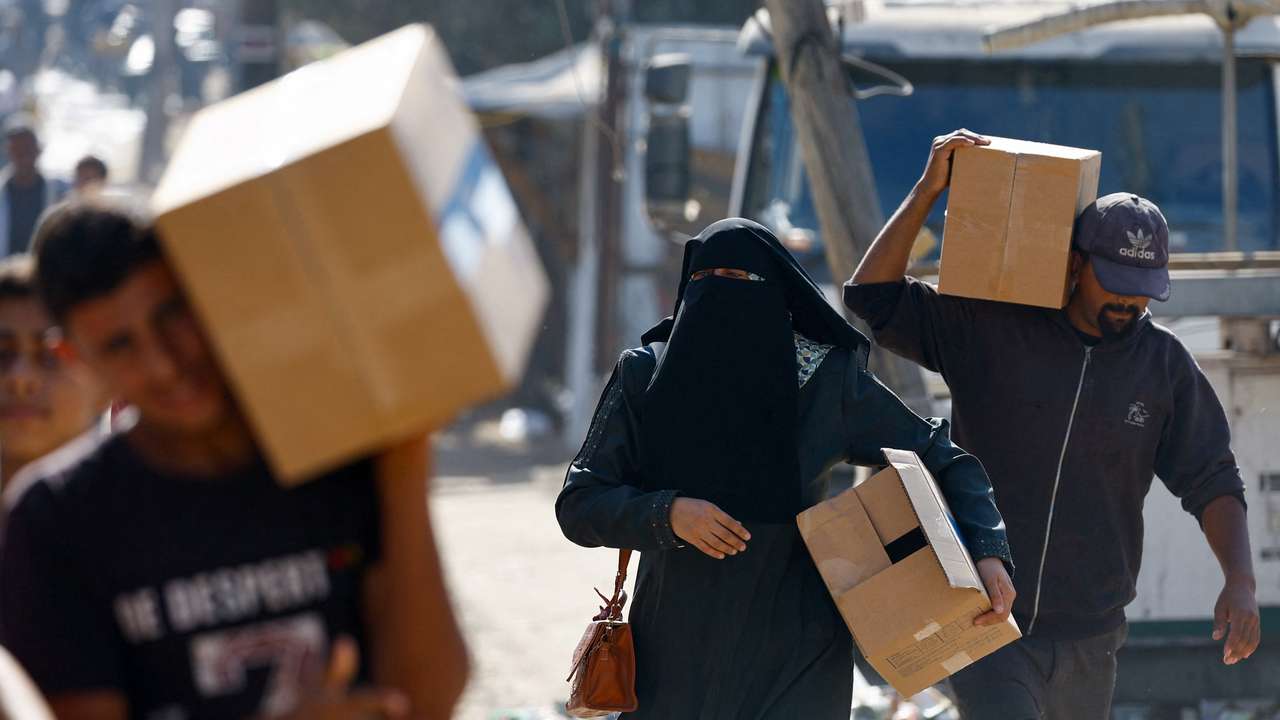 Palestinians carry aid that entered Gaza, in Zawaida