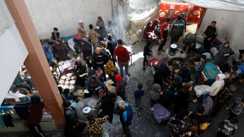Displaced Palestinians cook at a school sheltering people who fled their houses due to Israeli strikes, in Rafah