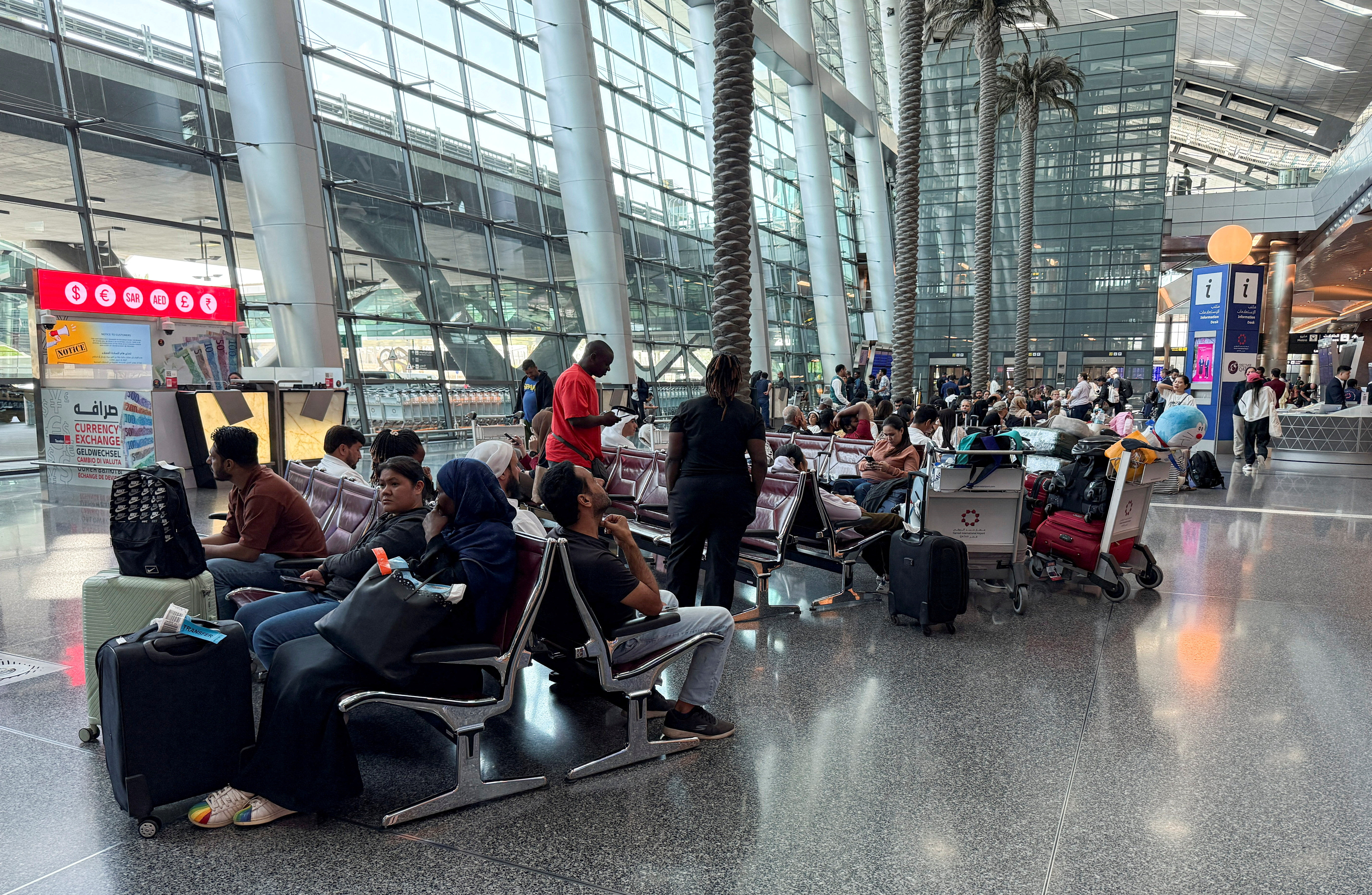 FILE PHOTO: People sit at Hamad International Airport, in Doha