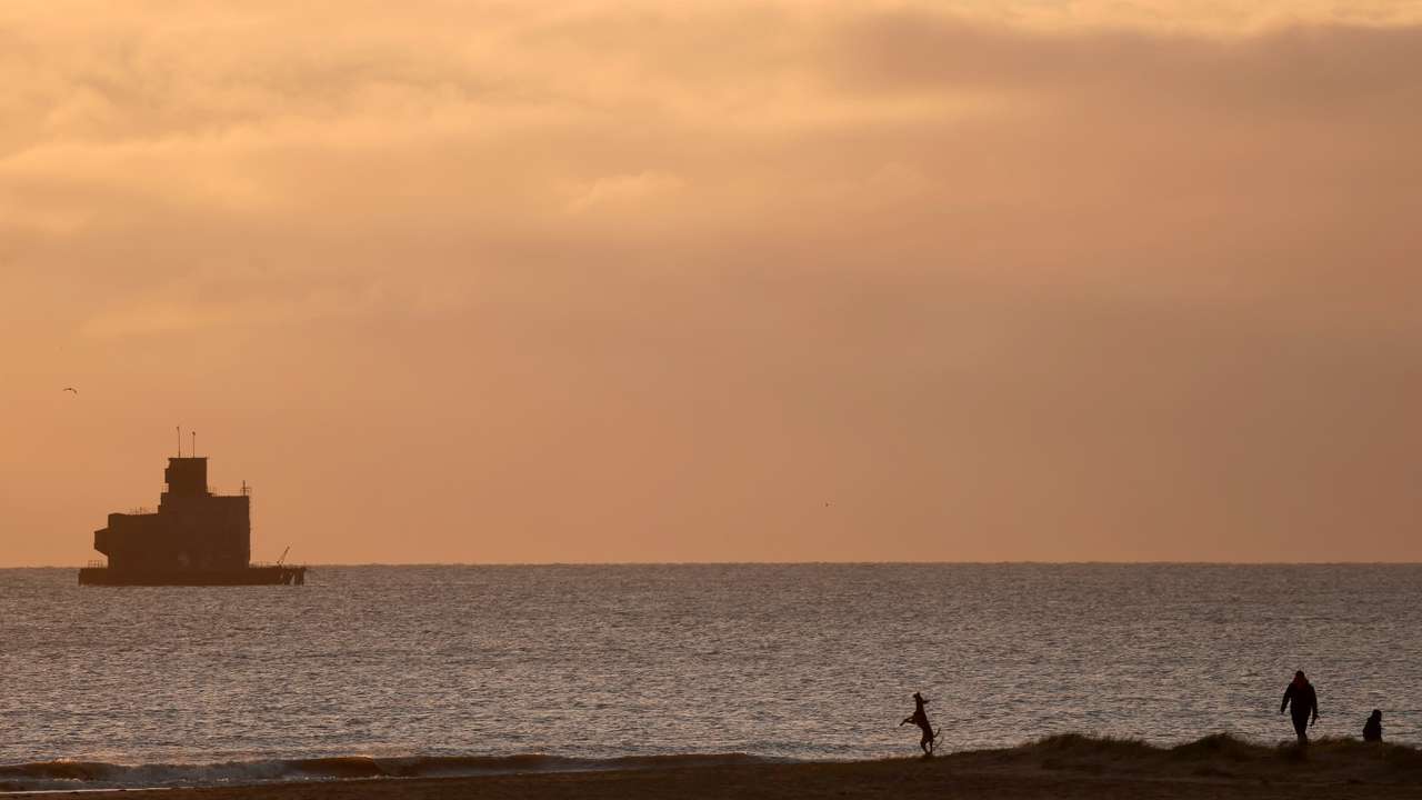 People visit the beach, near the location where a tanker carrying jet fuel for the U.S. military was hit by a container ship, off the coast of Cleethorpes