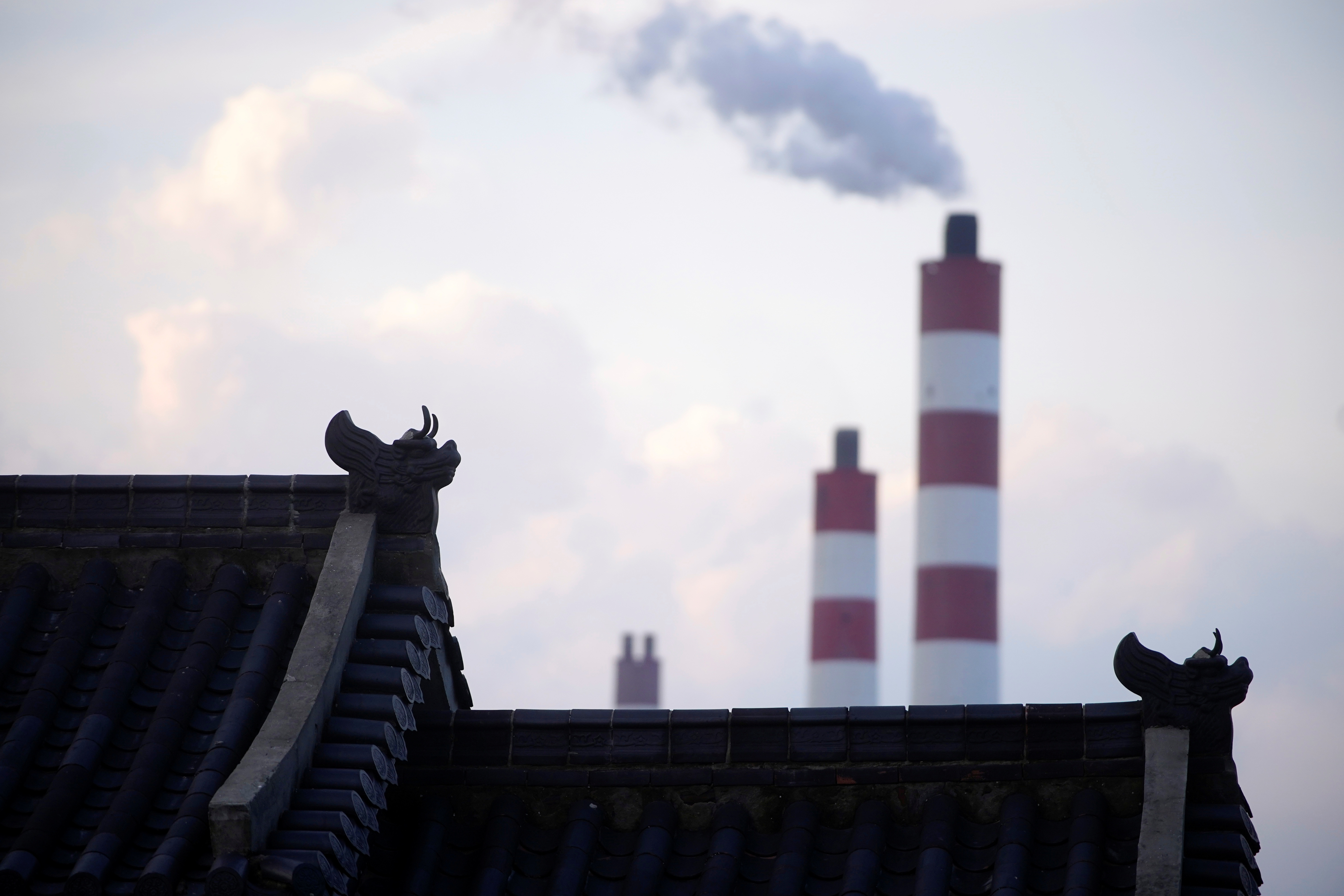 Chimneys of a coal-fired power plant are seen behind a gate in Shanghai