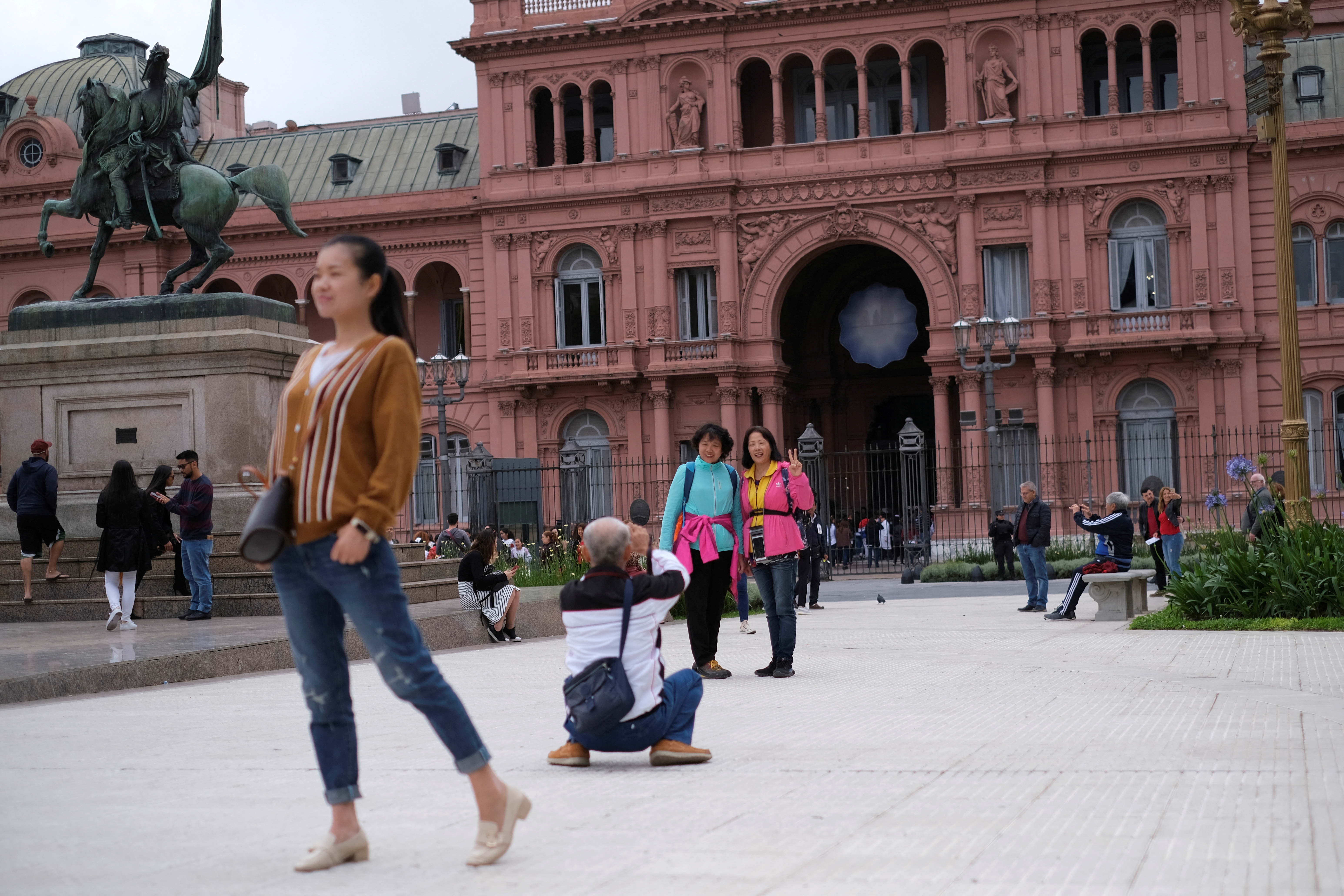 FILE PHOTO: Tourist pose for pictures in front of the presidential palace Casa Rosada in Buenos Aires