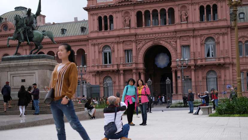 FILE PHOTO: Tourist pose for pictures in front of the presidential palace Casa Rosada in Buenos Aires