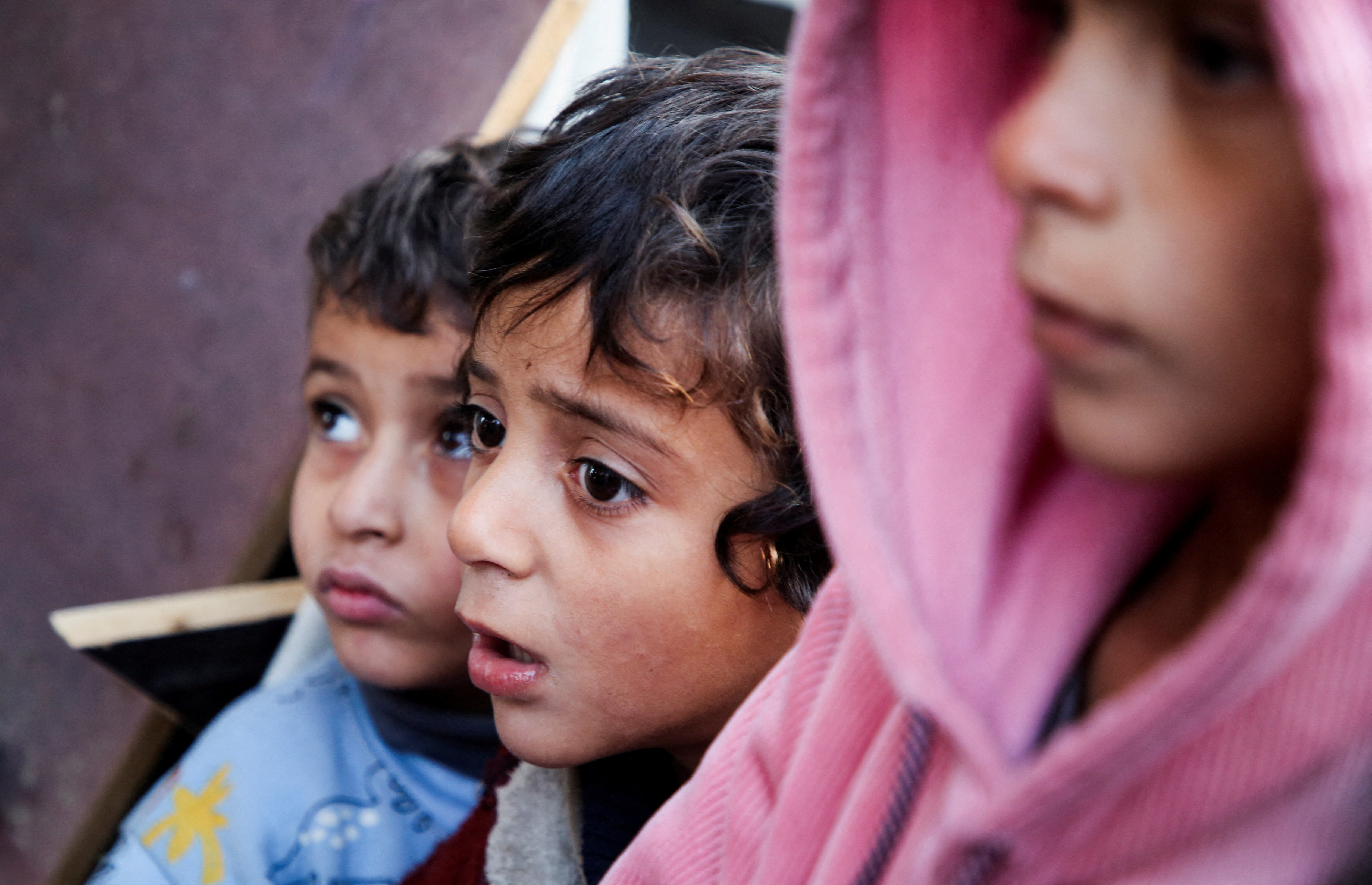 Palestinians react at a tent camp sheltering displaced people, in Khan Younis