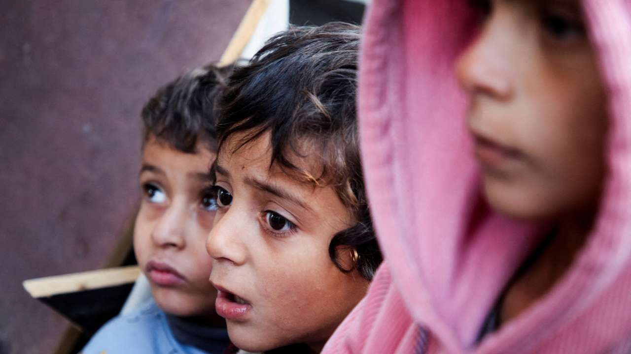 Palestinians react at a tent camp sheltering displaced people, in Khan Younis