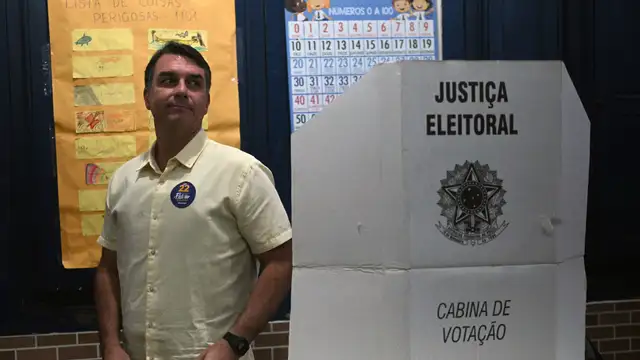 Flávio Bolsonaro sai de uma cabine de votação após registrar seu voto durante o segundo turno da eleição presidencial