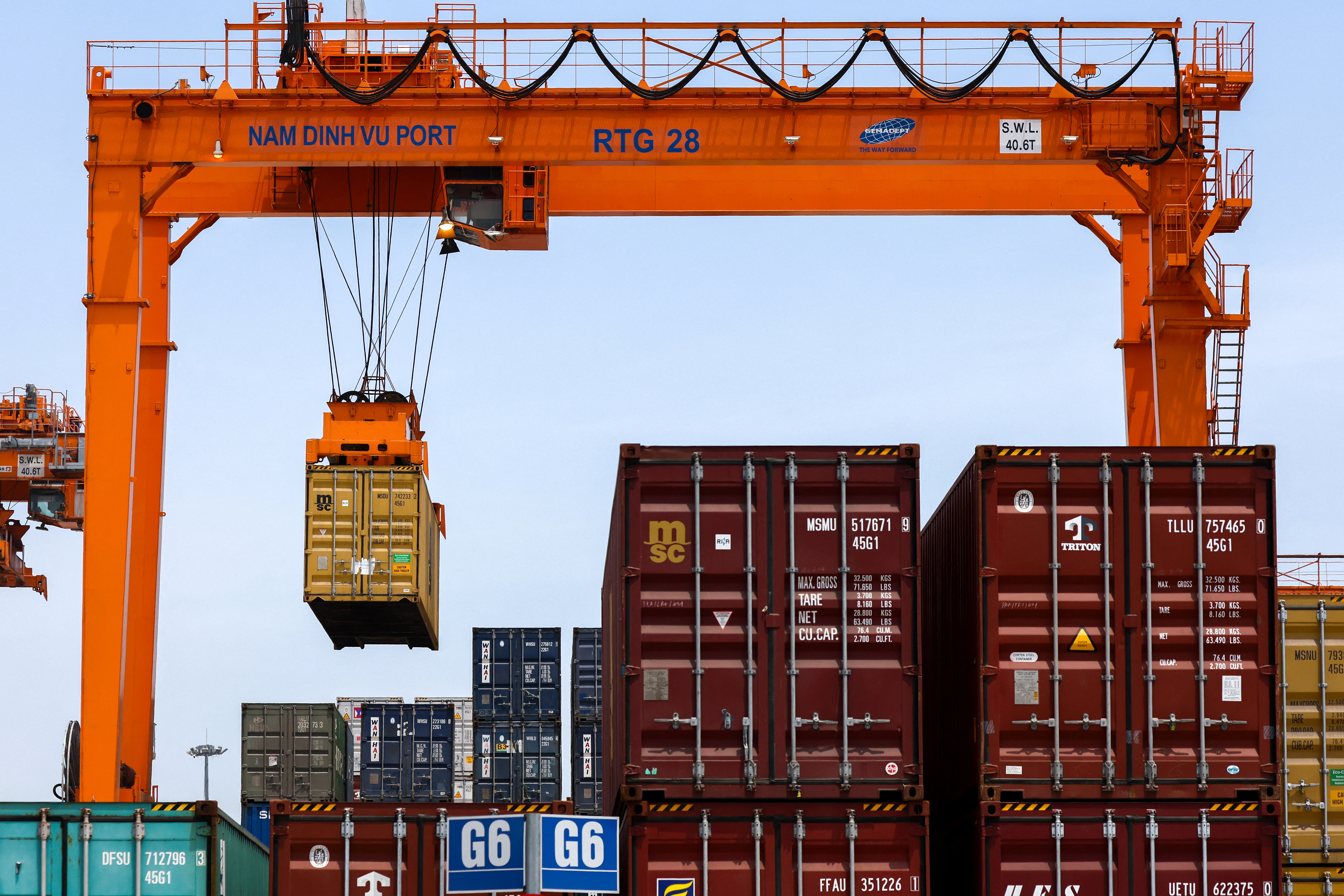 A container is loaded onto a cargo ship while docked at Hai Phong port in Vietnam