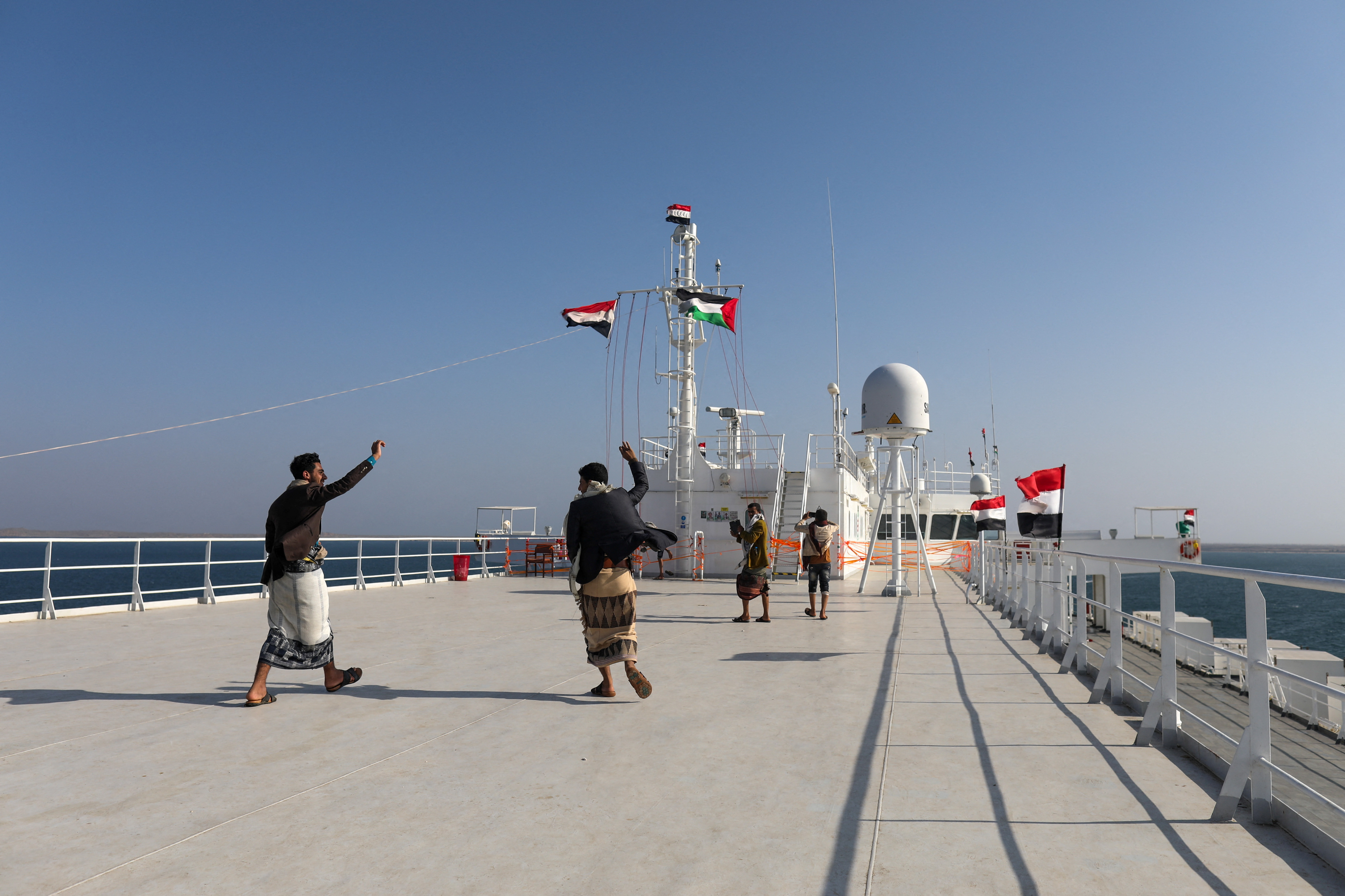 People dance on the deck of the Galaxy Leader commercial ship, seized by Yemen's Houthis last month, off the coast of al-Salif