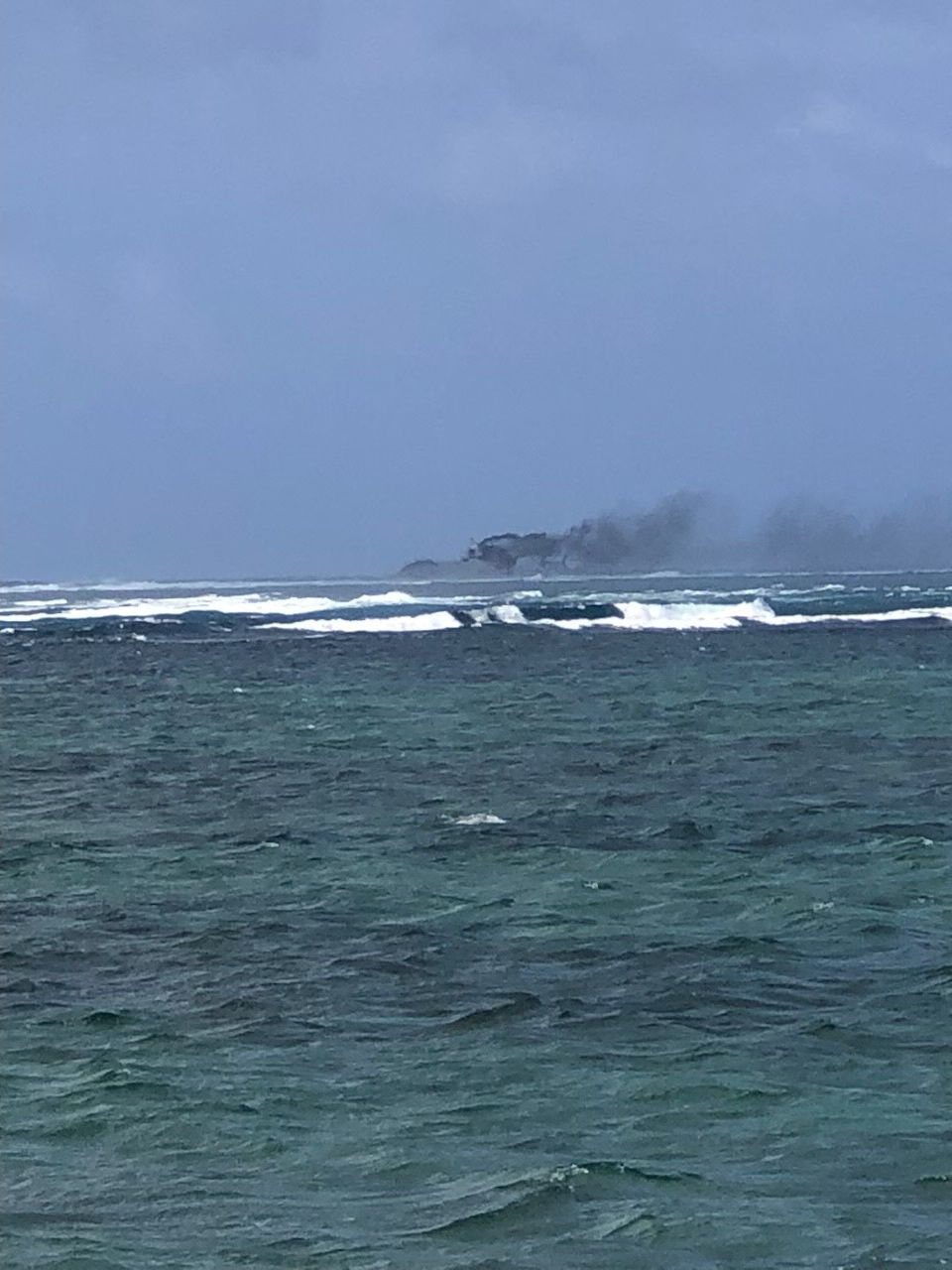 A view of a New Zealand Navy vessel on fire, as seen from Tafitoala