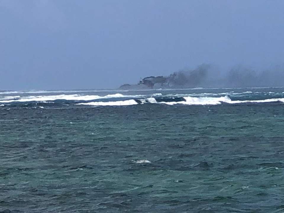 A view of a New Zealand Navy vessel on fire, as seen from Tafitoala