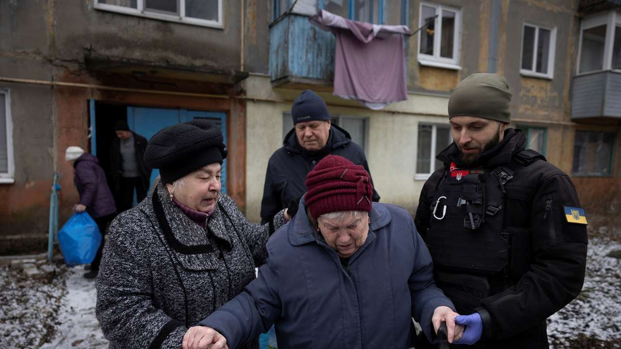 Volunteers of the East SOS non-governmental organisation evacuate Valentina Kitush from her home in Selydove