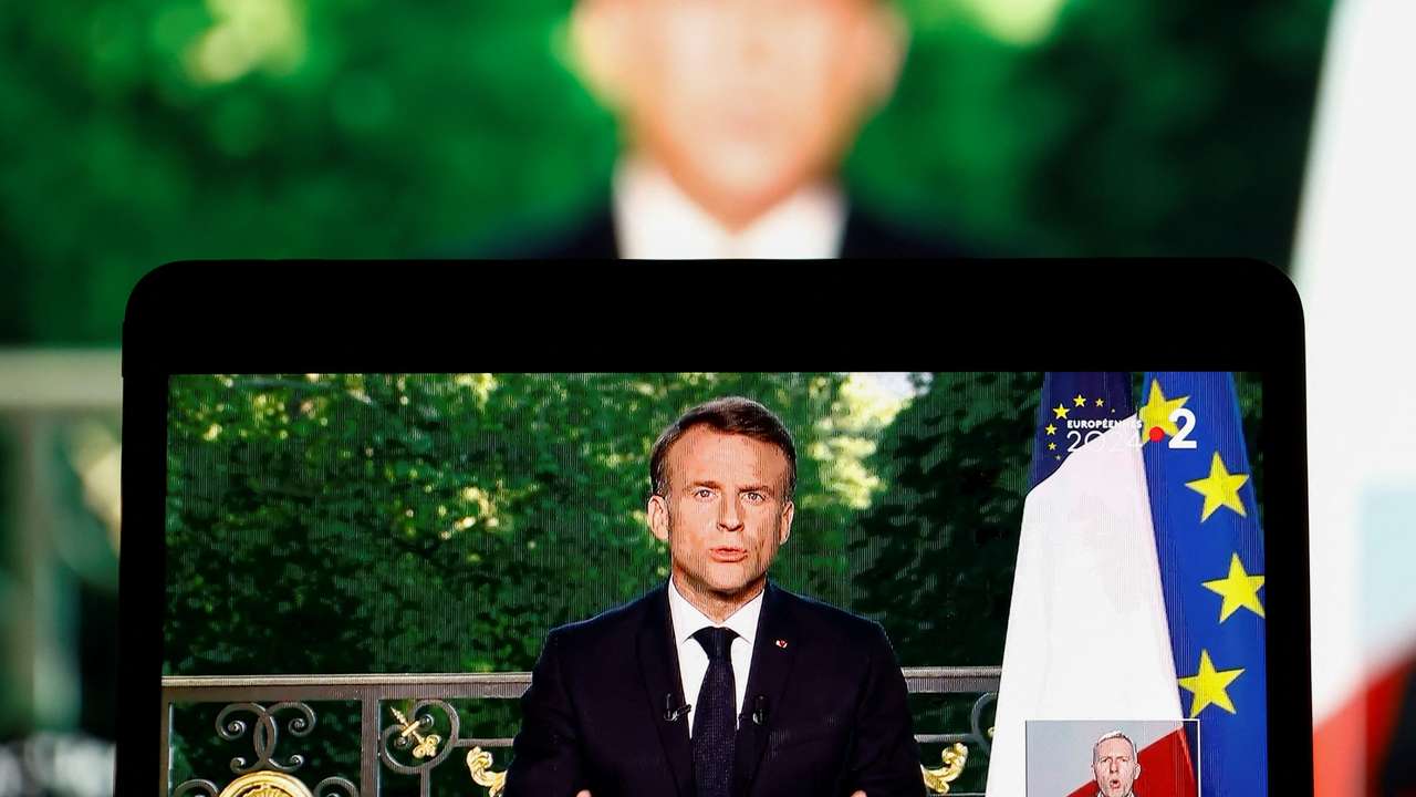 French President Emmanuel Macron appears on a screen as he delivers a speech following results after the polls closed in the European Parliament elections