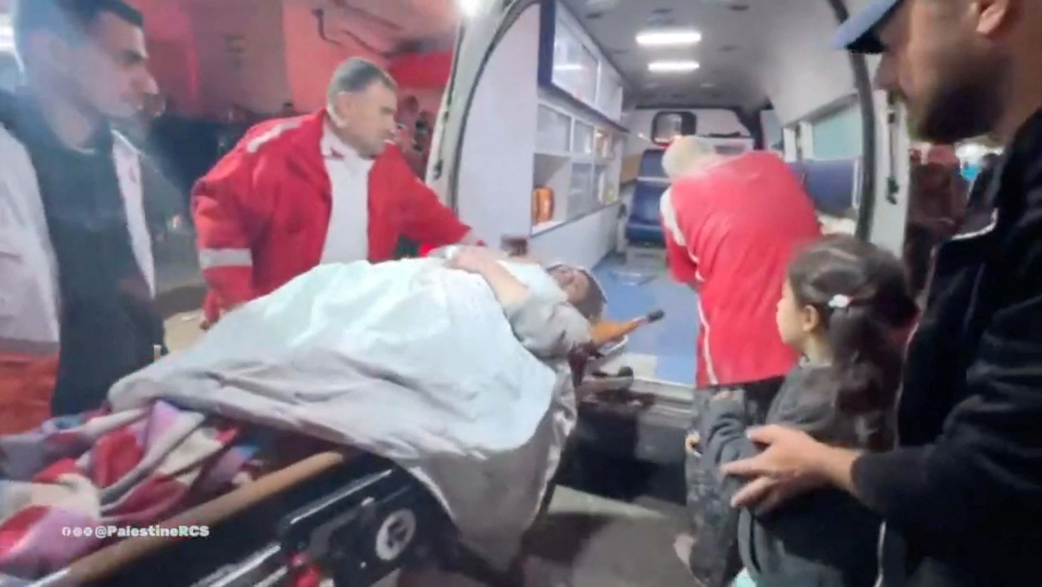 Injured Palestinians are transfered from ambulances to Shuhada al-Aqsa hospital in Deir Al-Balah